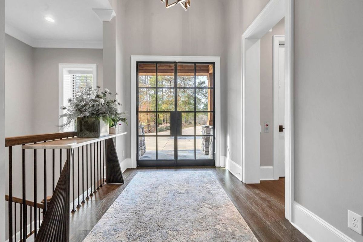 Bright entryway showcases a modern glass door with a view.