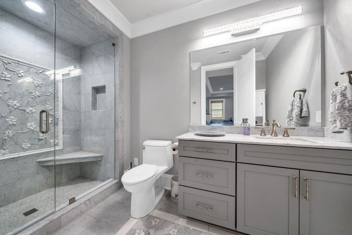 Bathroom combines a floral-accented marble shower.