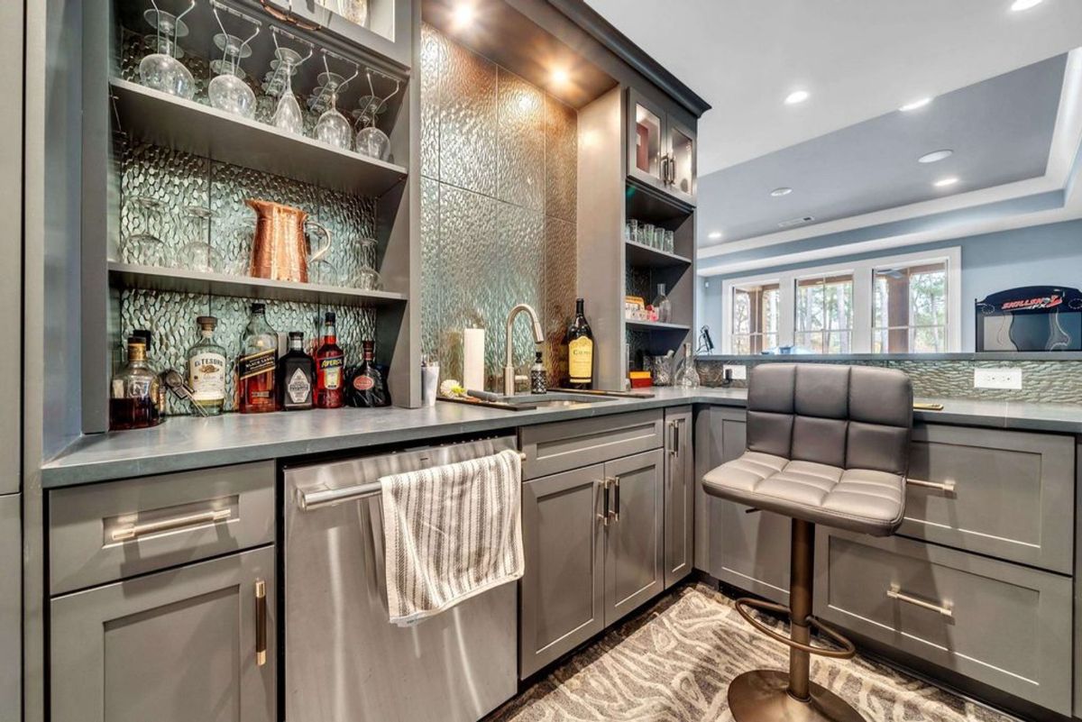 A chic home bar combines modern cabinetry.