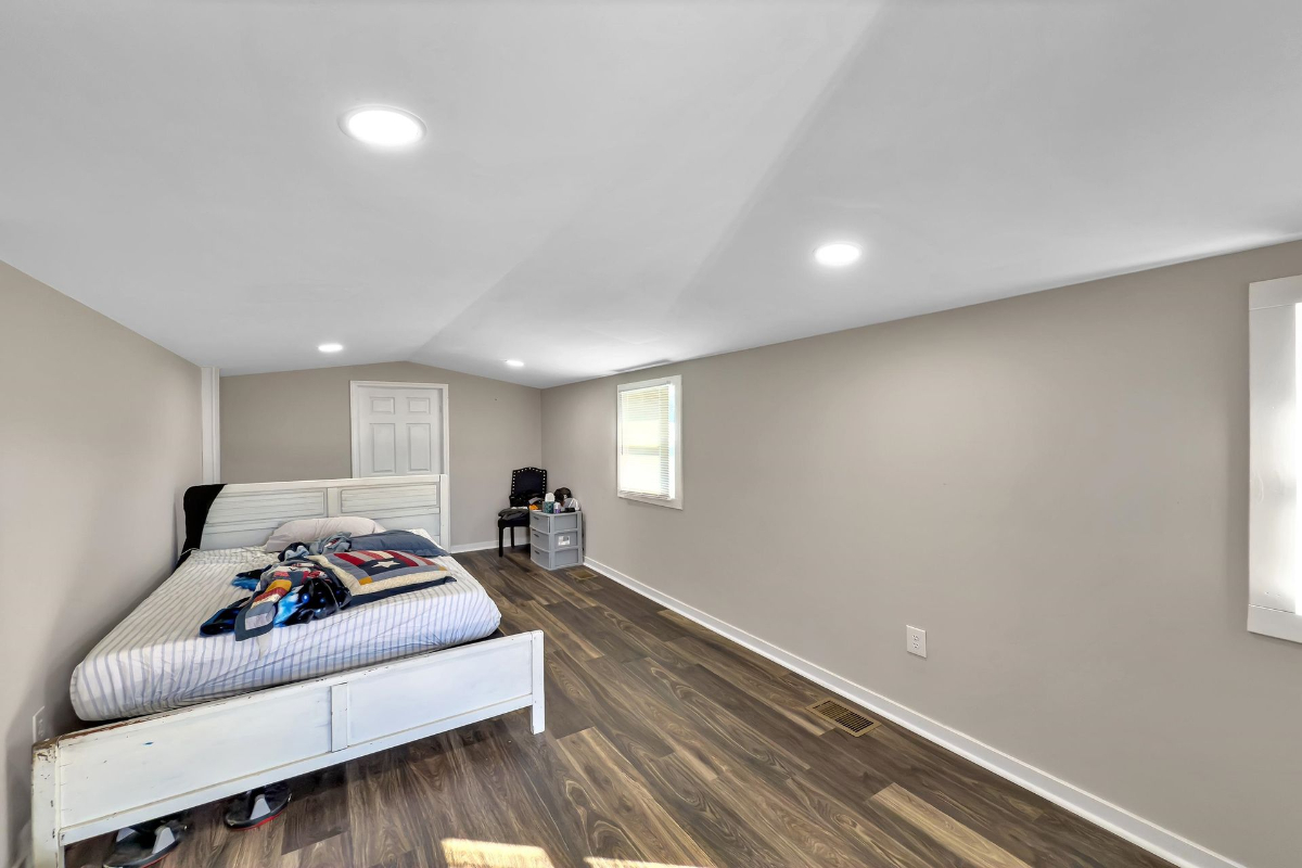 Secondary bedroom features durable wood-like flooring and ample space for personalization.