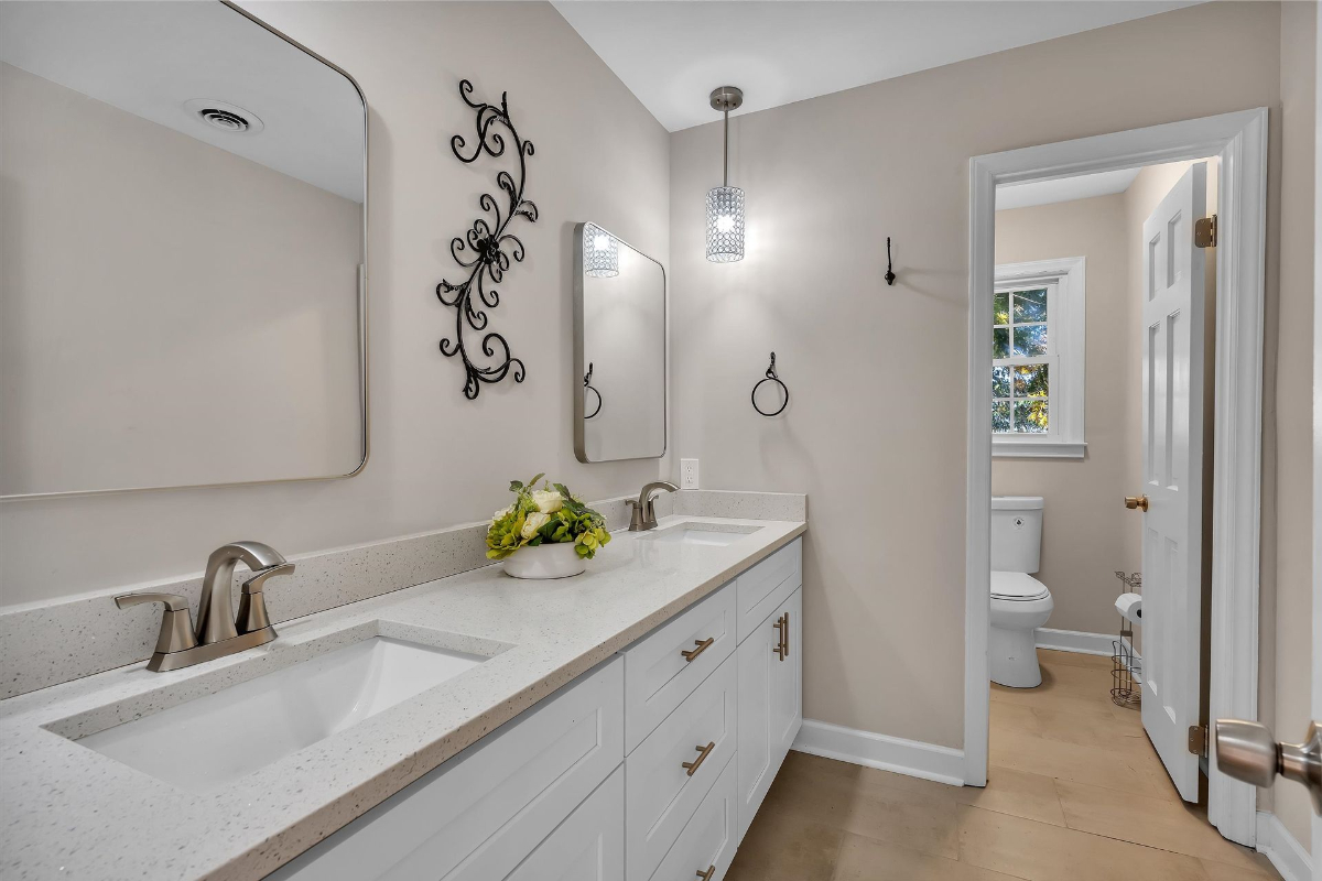 Secondary bathroom offers a sleek dual-sink vanity, contemporary lighting, and a neutral color palette for a calming atmosphere.