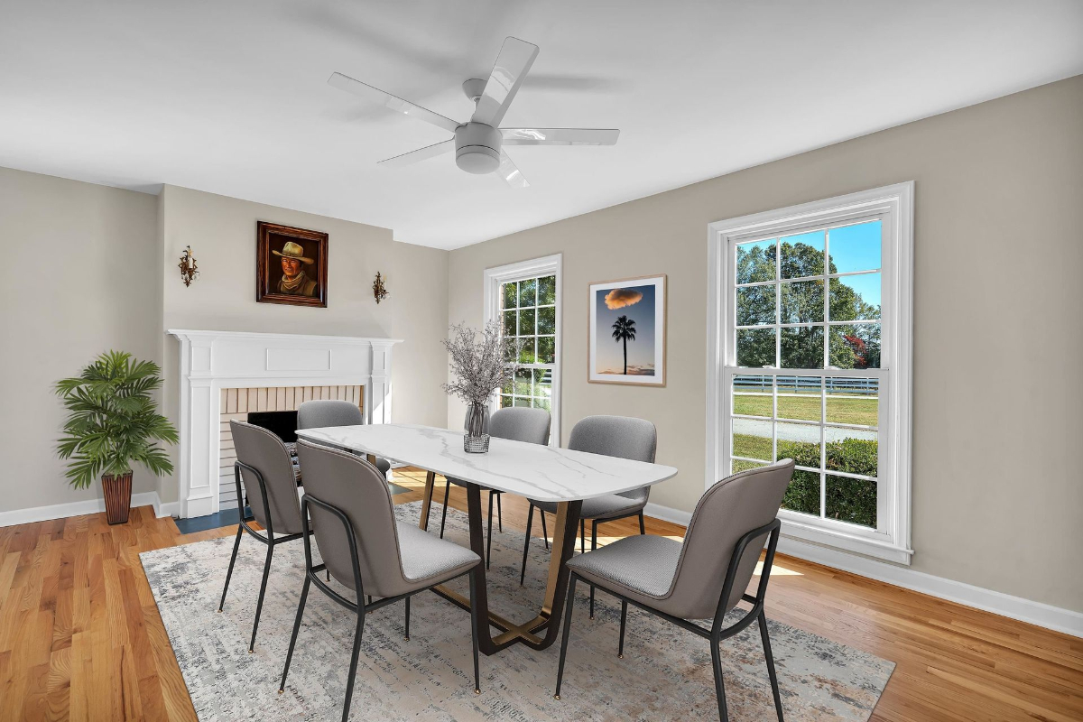 Formal dining room features large windows that frame serene outdoor views, a cozy fireplace.