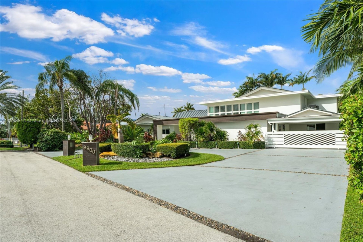 Contemporary driveway with manicured gardens and sleek house design.