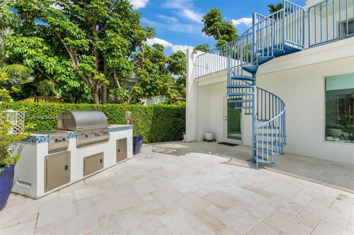 Outdoor dining and lounging area with poolside views and lush tropical landscaping.