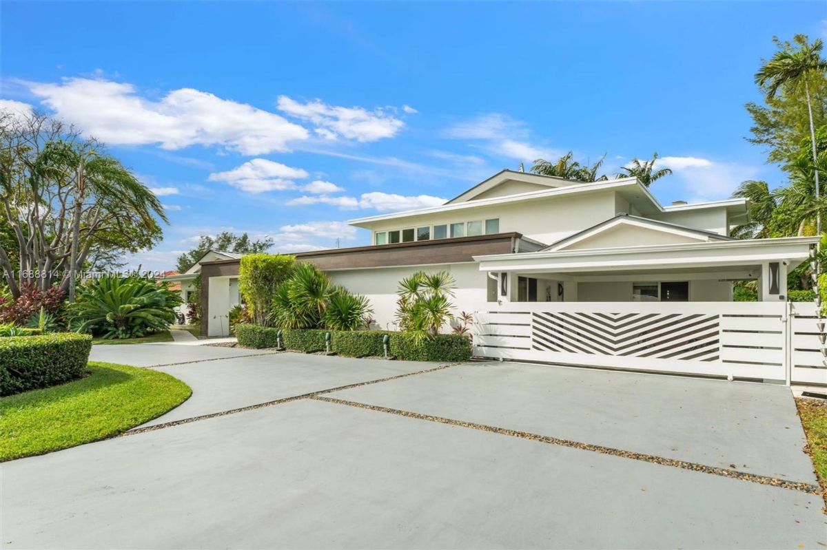 Modern front gate with minimalist landscaping and white architectural details.