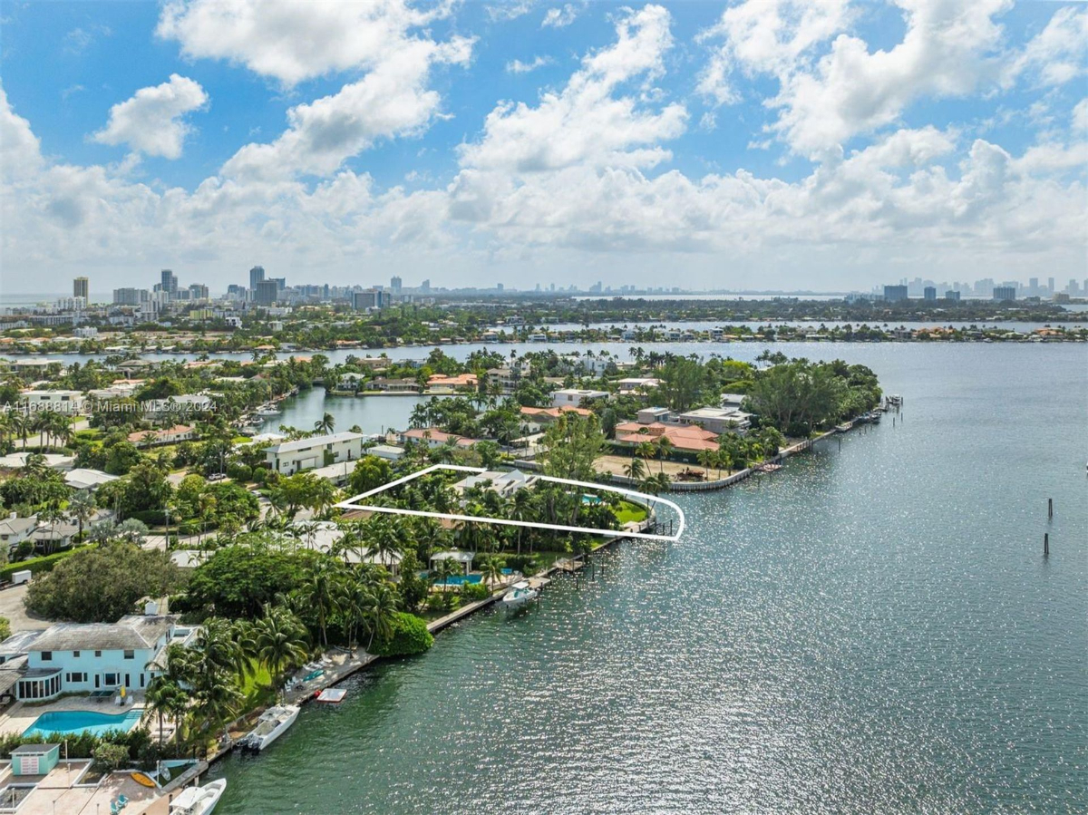 Highlighted aerial view showcasing a waterfront property with expansive city skyline in the background.