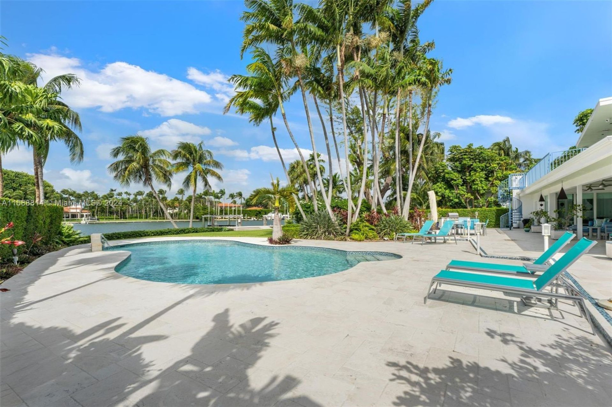 Resort-style pool area surrounded by lush landscaping and vibrant tropical foliage.