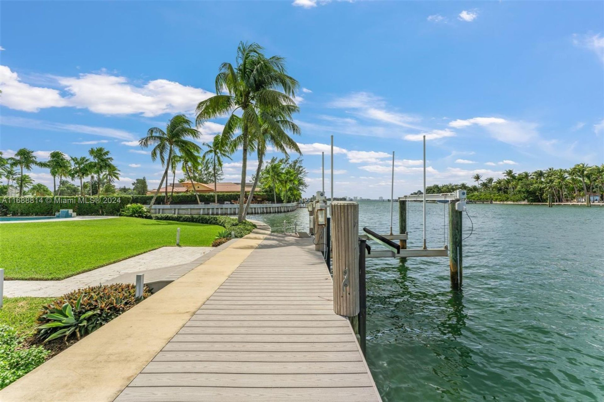 Private dock with water views and lush landscaping.