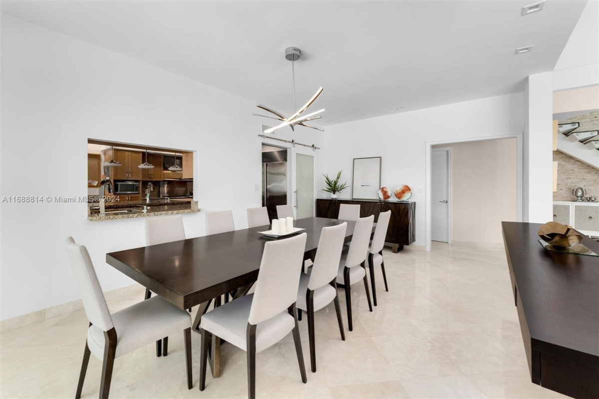 Spacious dining room with sleek white chairs and a contemporary open-concept design.