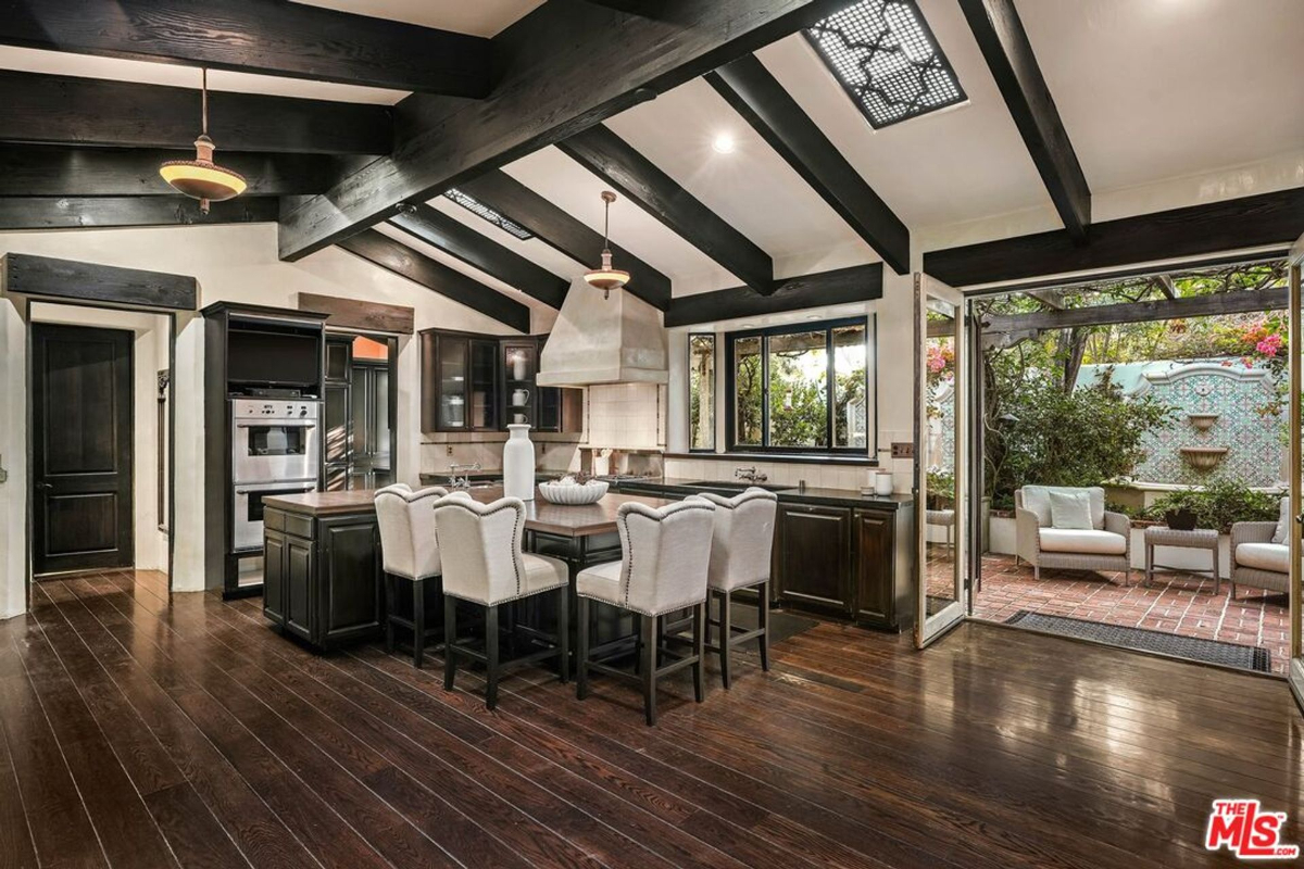 Open-concept kitchen with dark wood beams, an island, and seamless patio access.