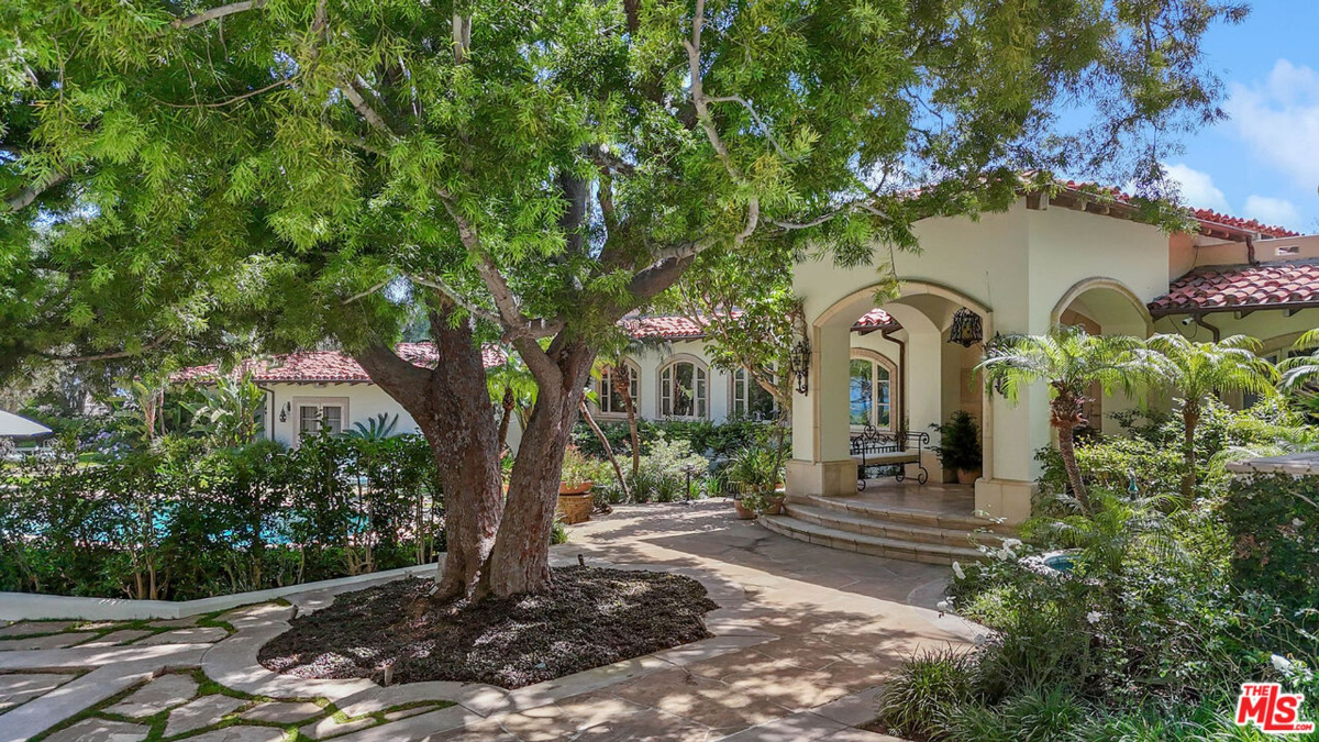 Shaded courtyard with elegant arches and lush greenery.