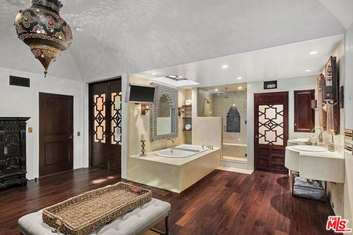 Luxurious spa-like bathroom with a soaking tub, walk-in shower, and ornate Moroccan-inspired accents.