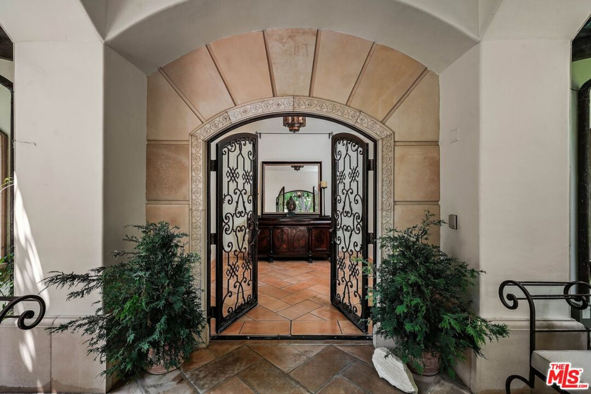 Elegant wrought-iron double doors opening to a warm and inviting interior.