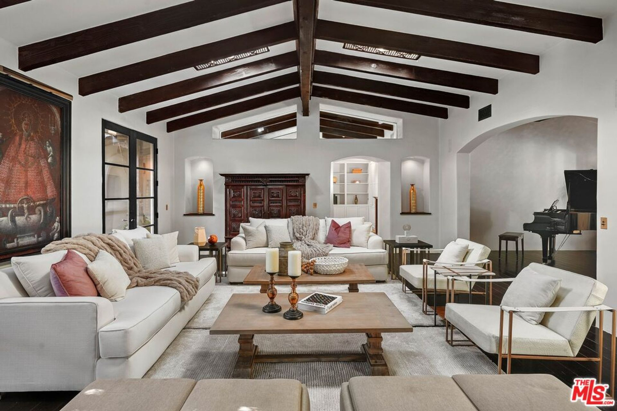 Spacious living room with vaulted wood-beamed ceilings, cozy seating, and elegant decor.