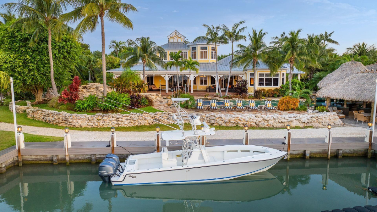 Waterfront estate boasts a private dock, tropical landscaping, and inviting outdoor amenities.