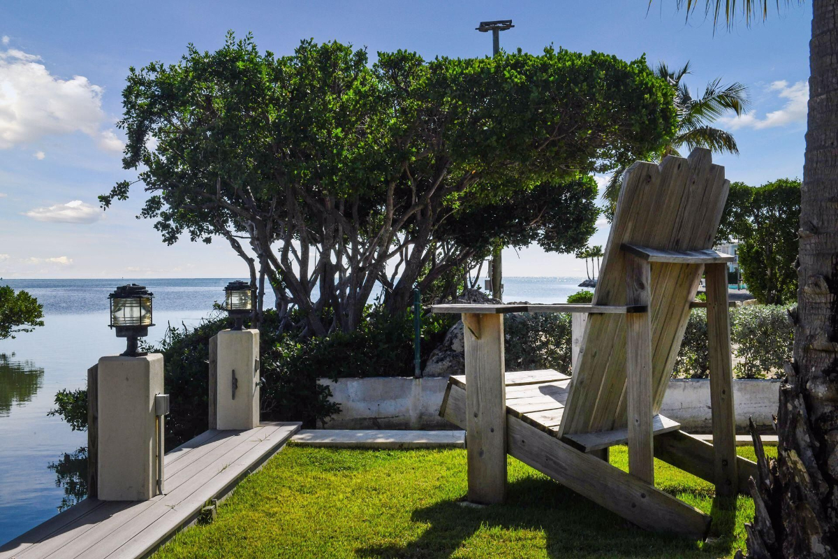 Seating area offers picturesque views of the calm waters and lush greenery.