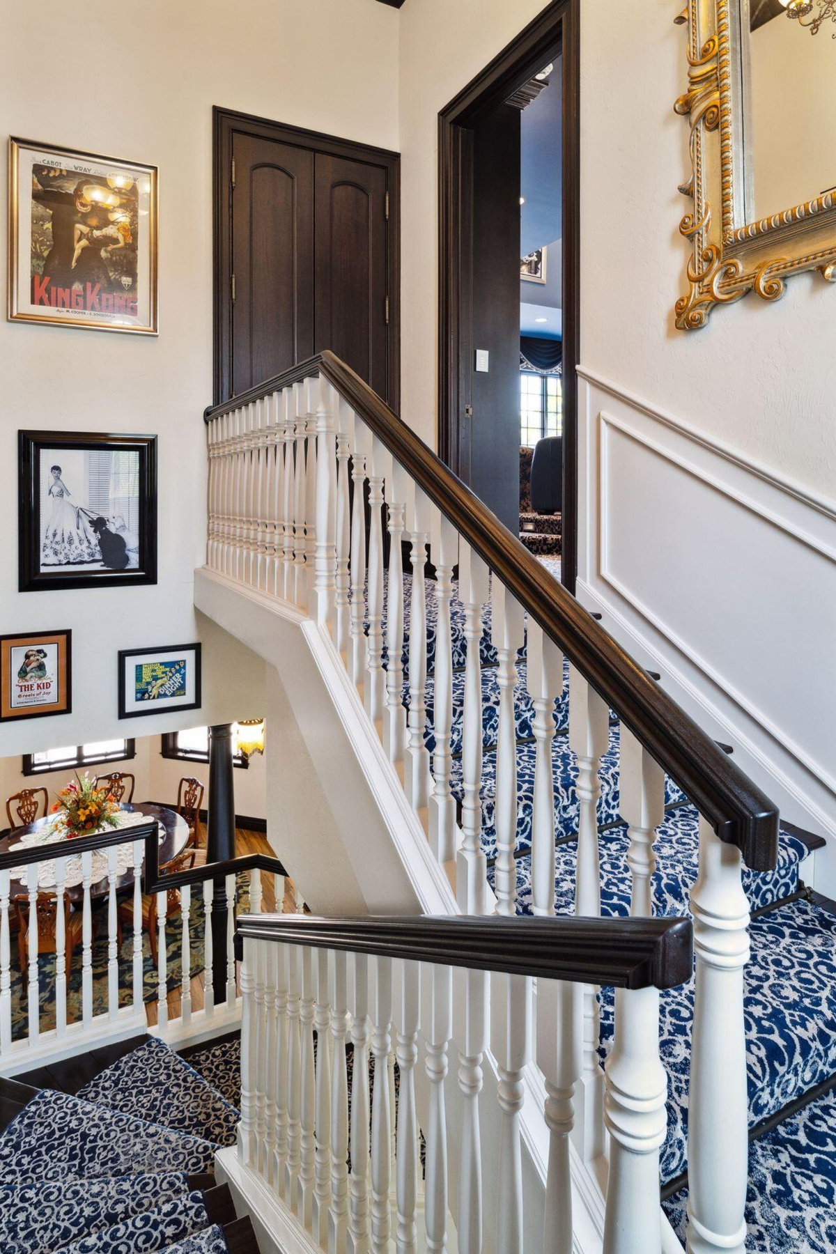 Intricate wall art and classic railing designs enhance the stairwell's refined character, leading to a stately upstairs landing.