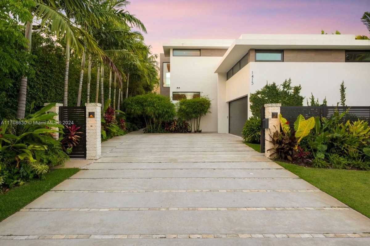 Modern exterior with clean lines and lush tropical landscaping.