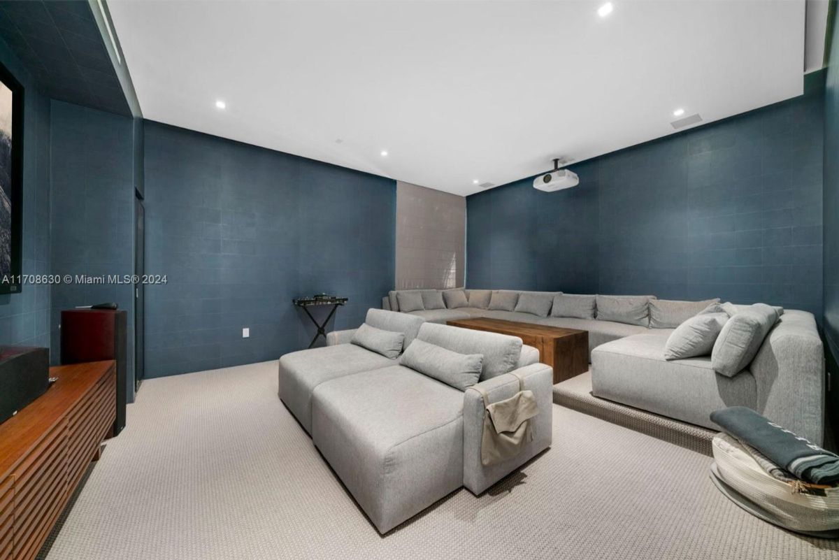 Home theater lounge with ample seating, plush sofas, and a modern projector setup.