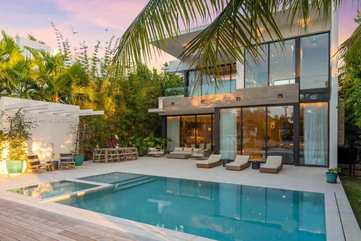 Modern poolside retreat with lounge chairs and lush landscaping.