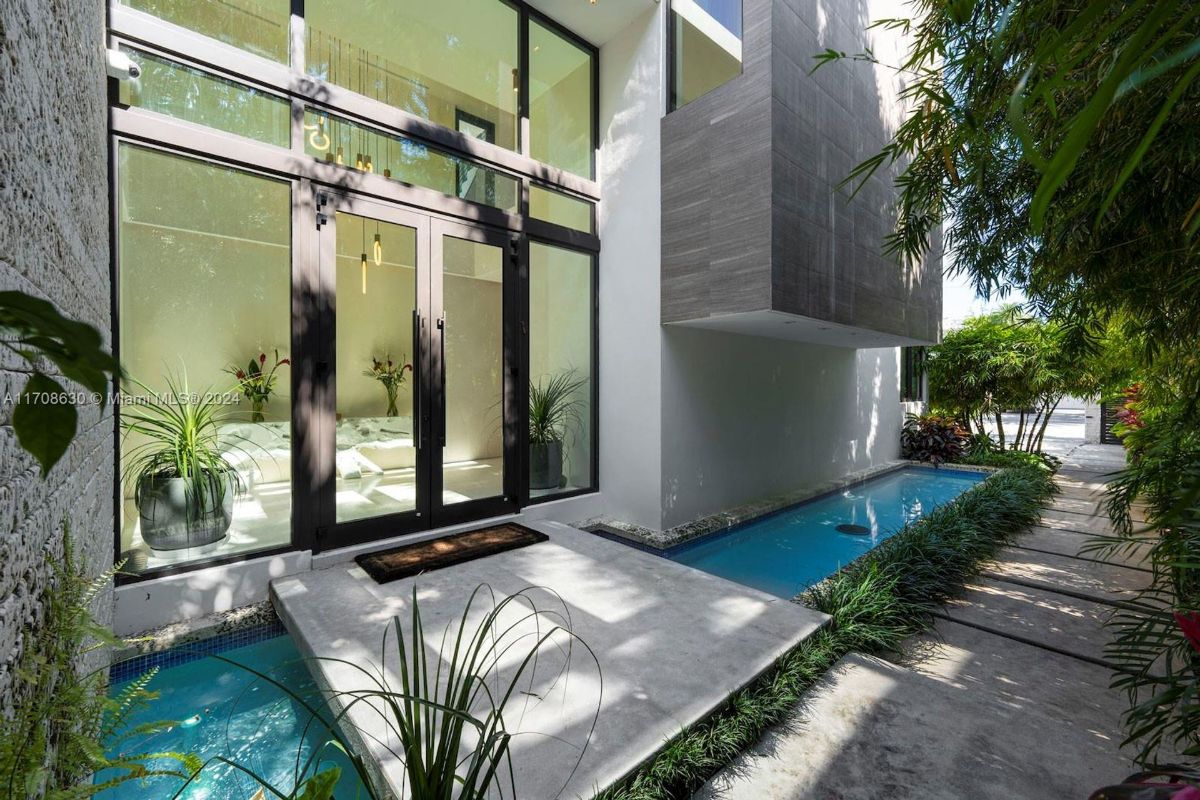 Elegant front entry with a water feature and lush landscaping.