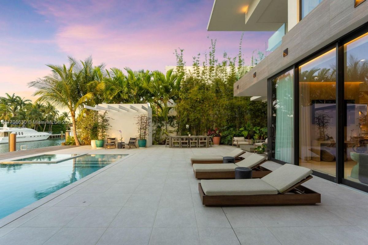 Elegant outdoor lounge area with poolside sunbeds and lush tropical landscaping.