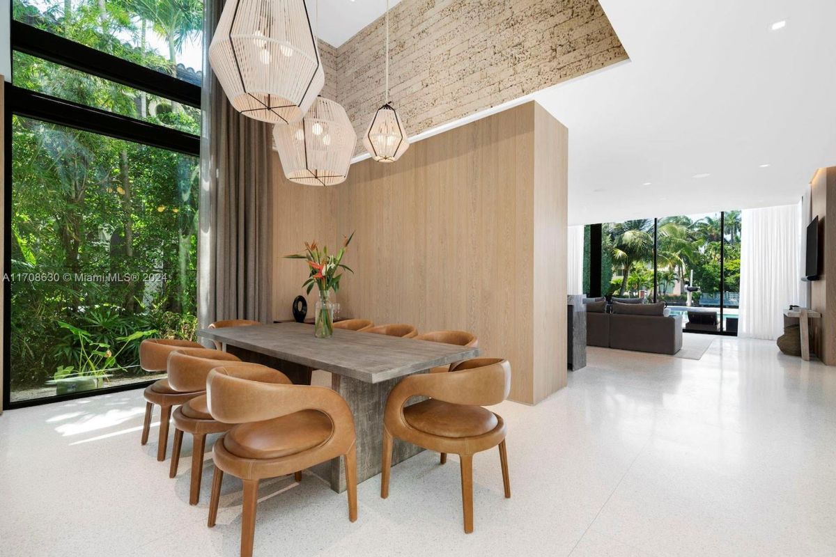 Modern dining space featuring leather chairs and oversized pendant lighting.