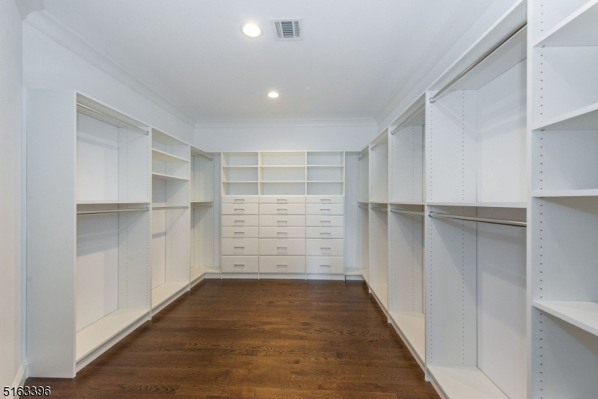 Expansive walk-in closet with ample shelving and storage drawers.