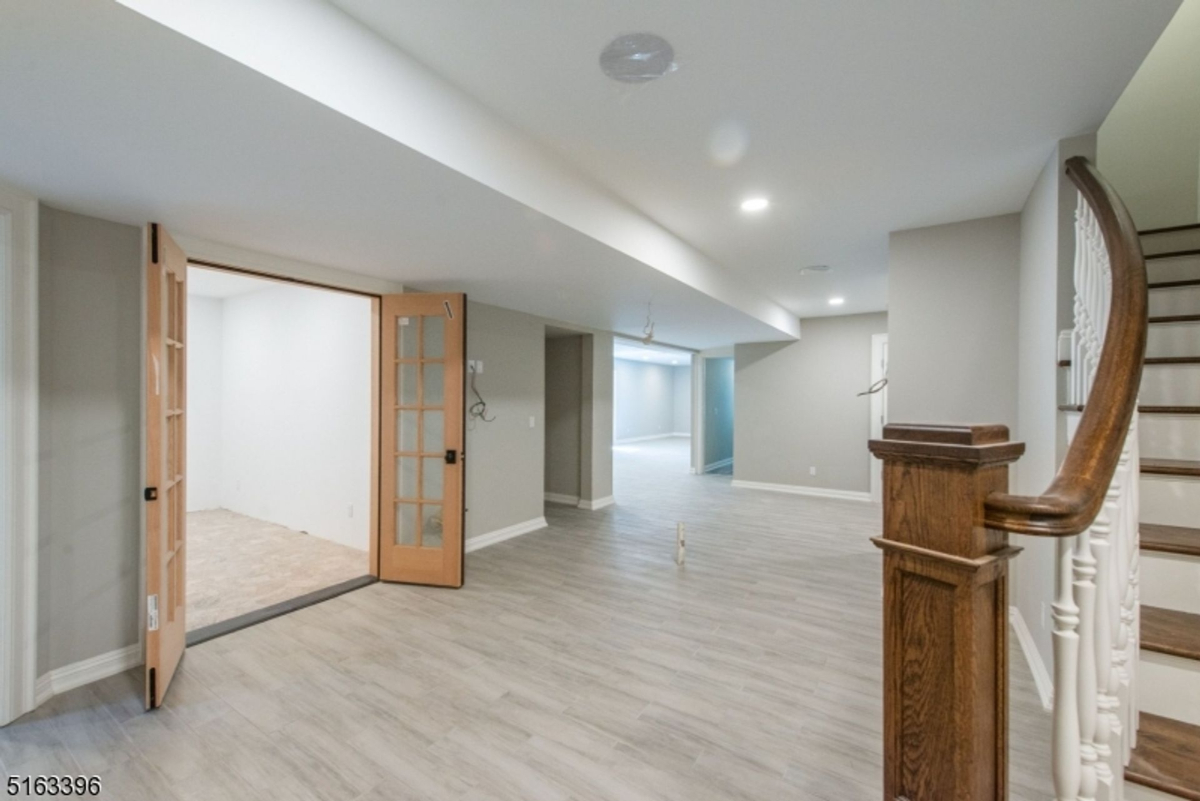 Spacious lower level offering versatile open areas with sleek flooring and natural light accents.