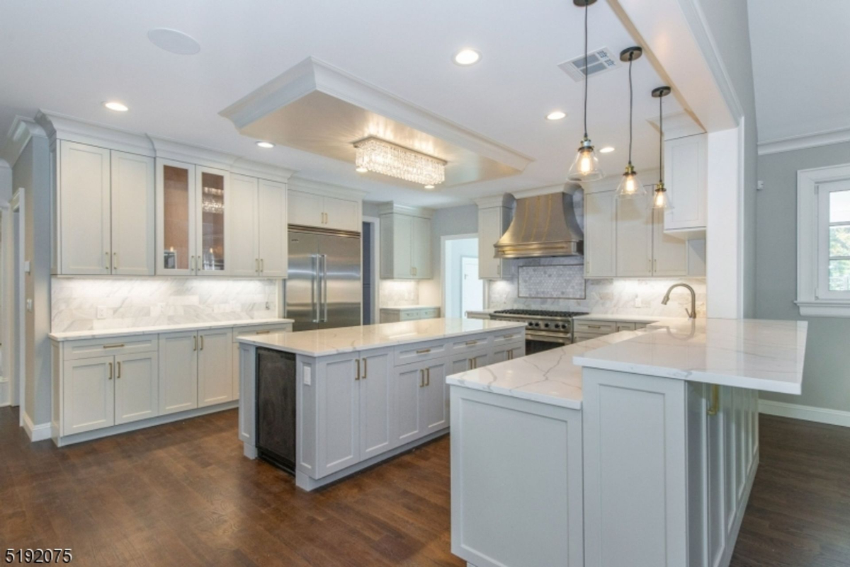 Chef-inspired kitchen showcasing marble countertops, custom cabinetry, and a grand center island.