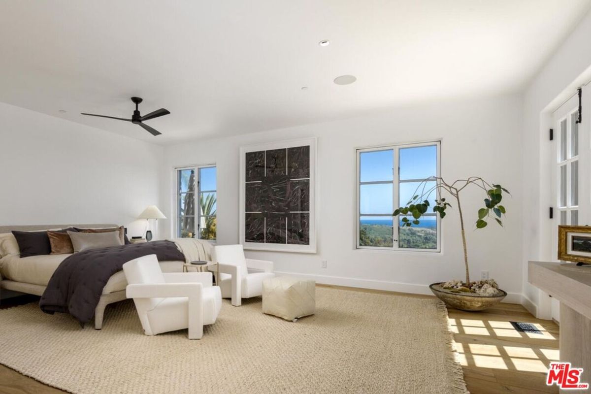 Minimalist design and natural tones highlight this serene bedroom, offering ocean views through expansive windows.