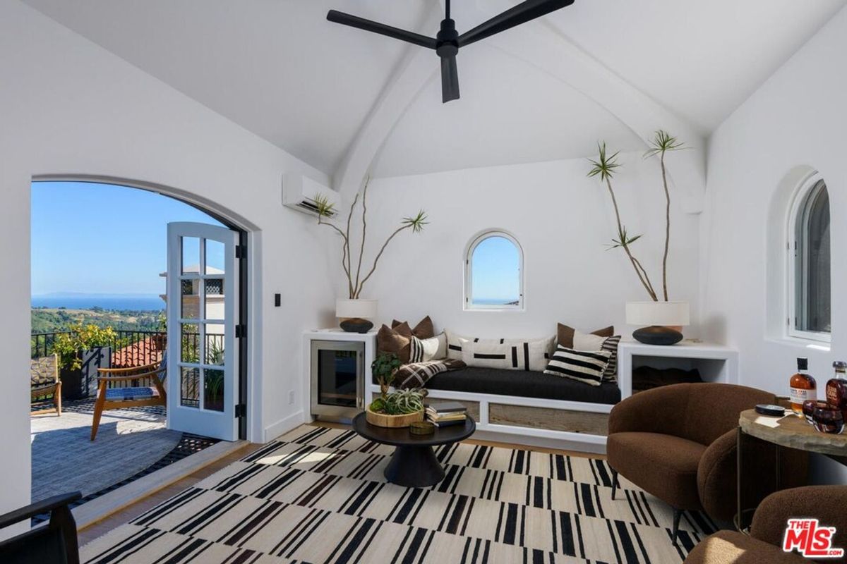 Airy lounge with arched windows and doors opens to breathtaking views.