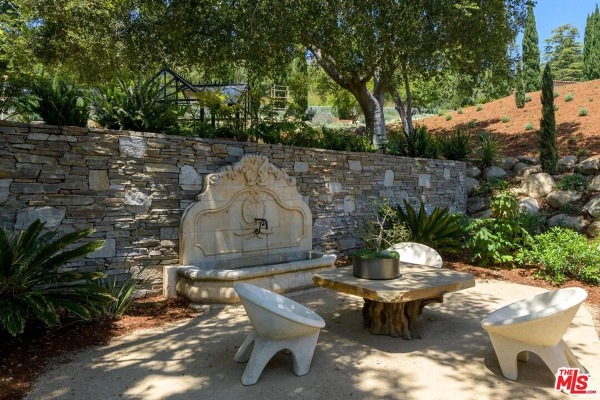 Stone fountain anchors this serene outdoor seating area.