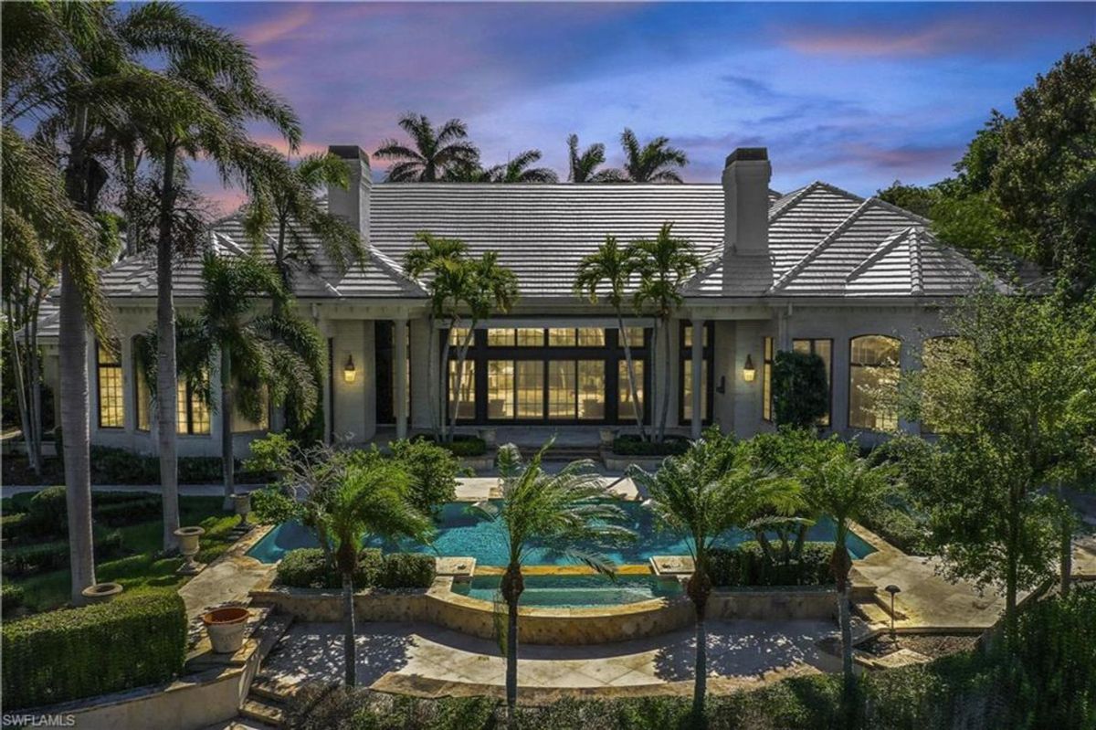 Illuminated by warm evening light, this luxurious residence showcases an inviting pool and spa surrounded by lush tropical landscaping and elegant architectural design.