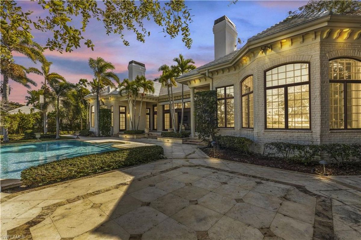 Illuminated by warm evening light, this luxurious residence showcases an inviting pool and spa surrounded by lush tropical landscaping and elegant architectural design.