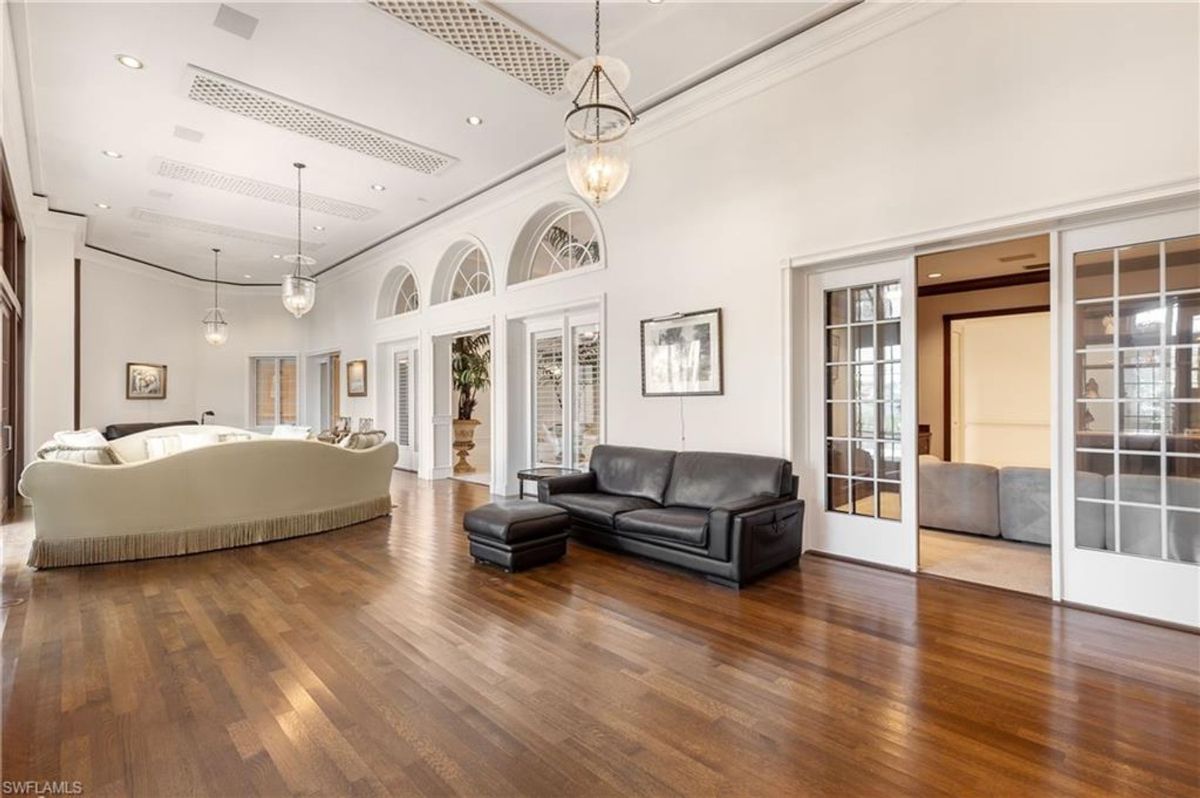 Living area features polished hardwood floors, sophisticated lighting, and expansive French doors for a seamless indoor-outdoor transition.