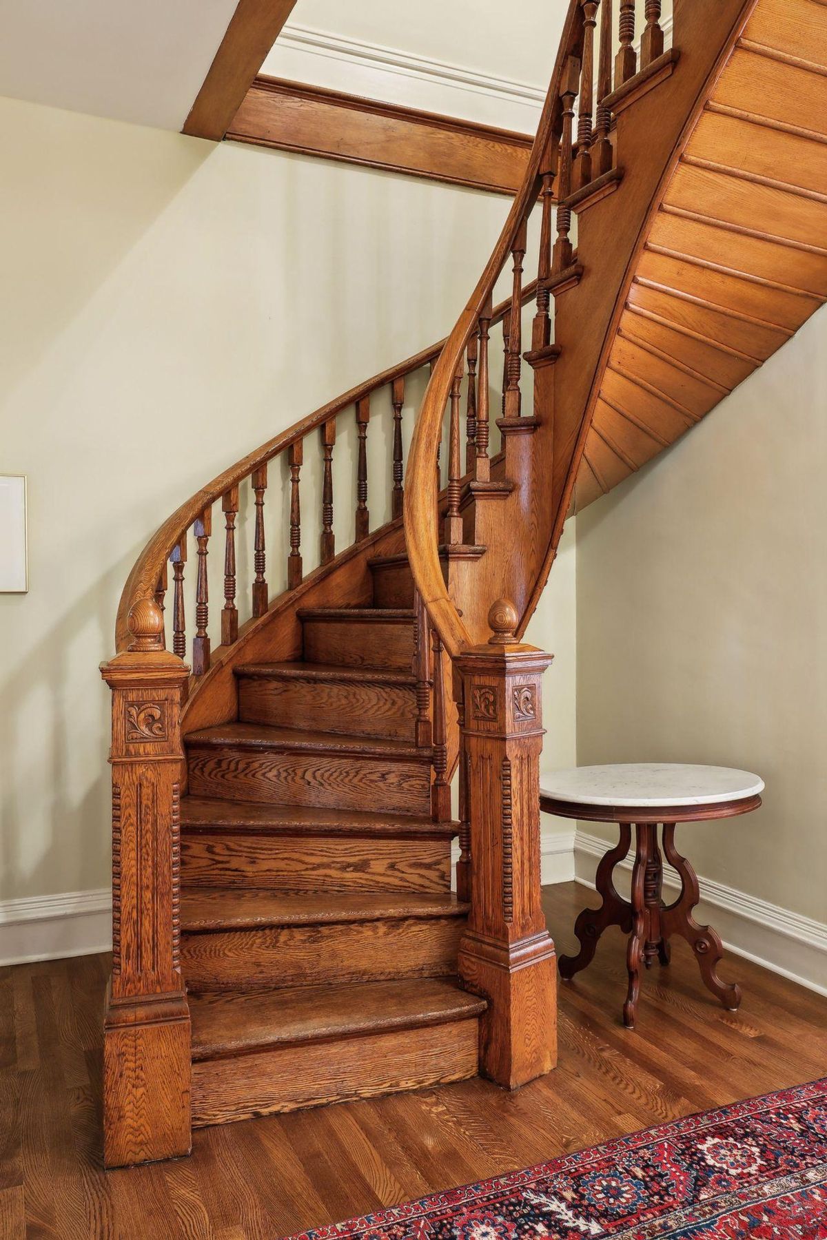 A beautifully crafted wooden spiral staircase is the focus of this image.