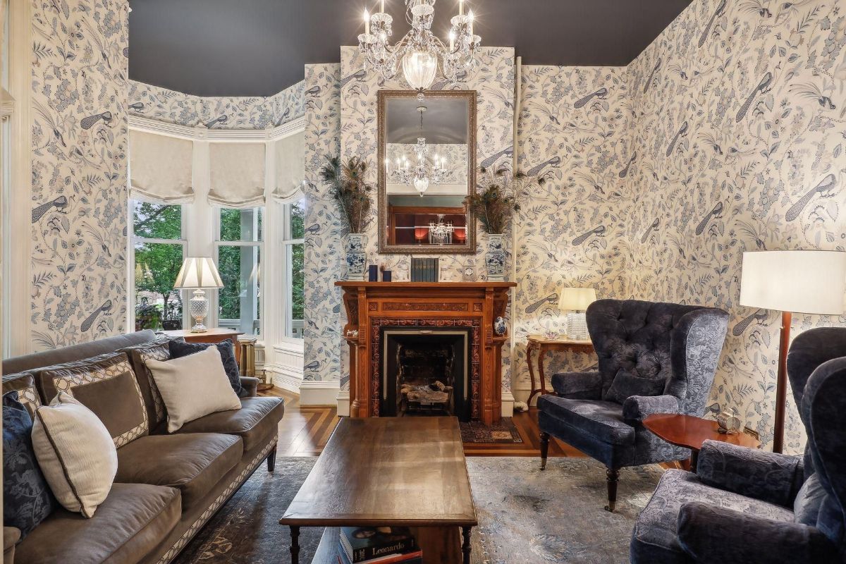 Living room features a fireplace, patterned wallpaper, and comfortable seating.