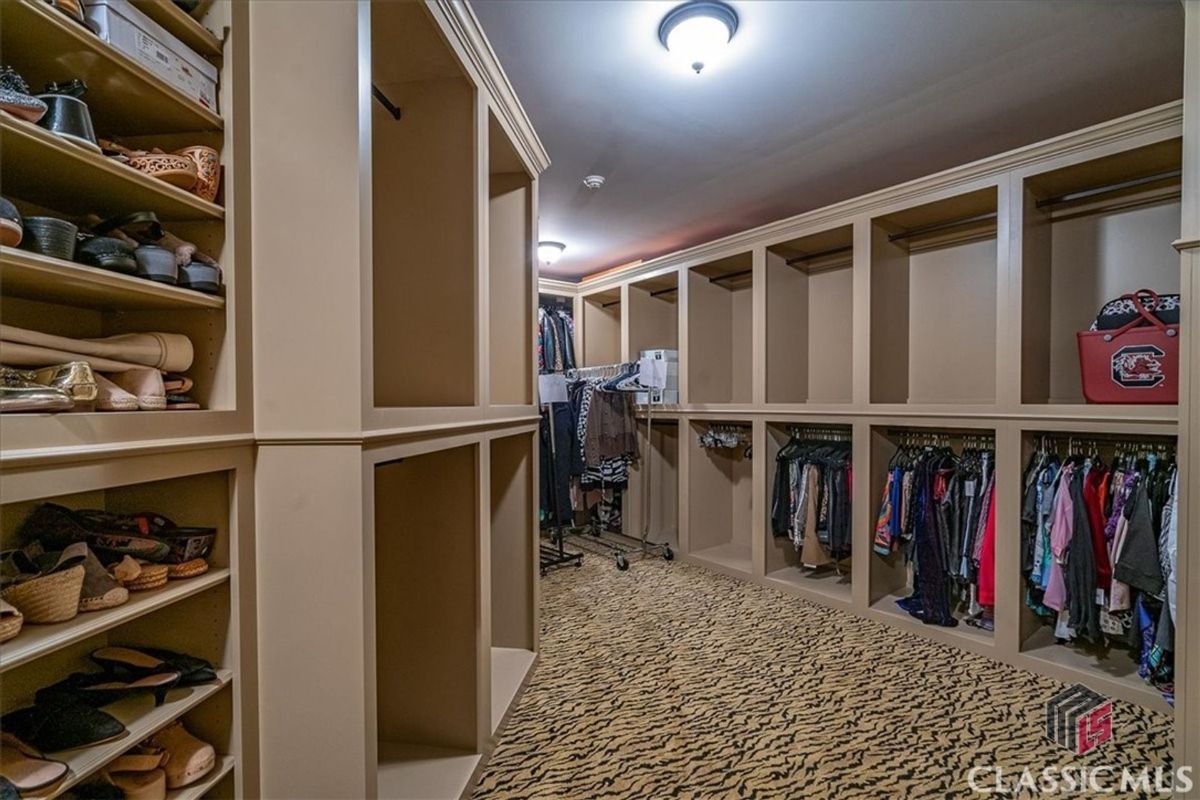 A walk-in closet featuring custom shelving and ample hanging space provides a functional and stylish storage solution.