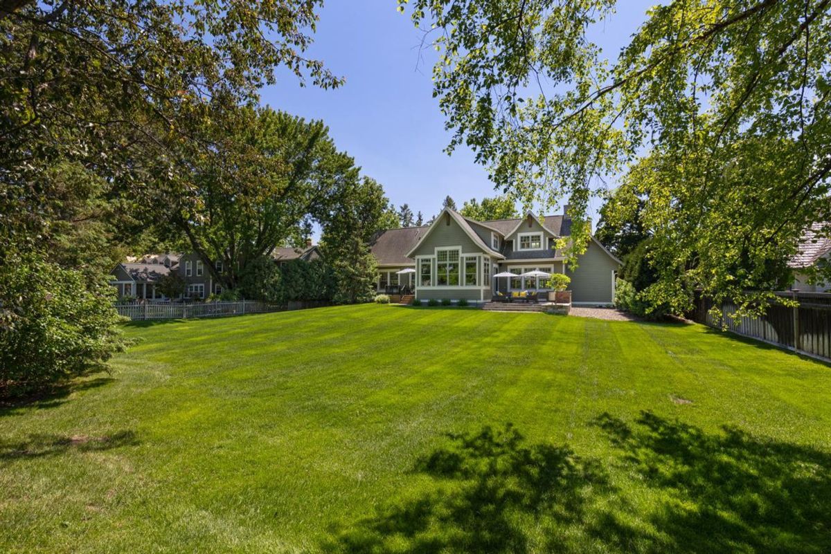 Expansive backyard framed by mature trees offers a serene and private outdoor retreat.