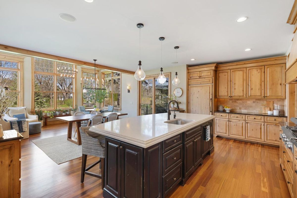 Open kitchen and dining space features large windows, natural wood finishes, and elegant lighting.