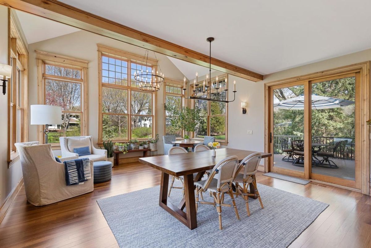 Sunlit dining area boasts vaulted ceilings, expansive windows, and seamless access to the outdoor patio.