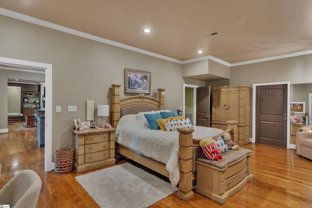 A spacious bedroom combines rustic wood furniture with playful, colorful accents for a cozy yet vibrant ambiance.