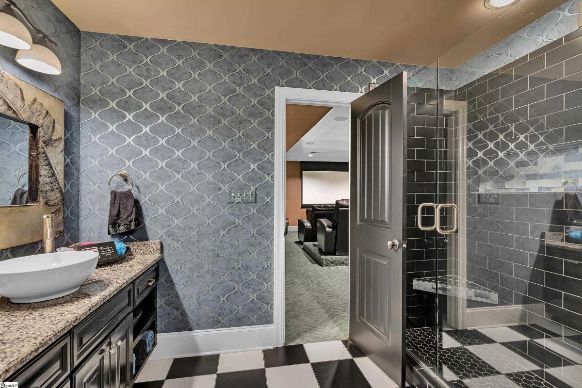 A chic bathroom features bold patterned wallpaper.