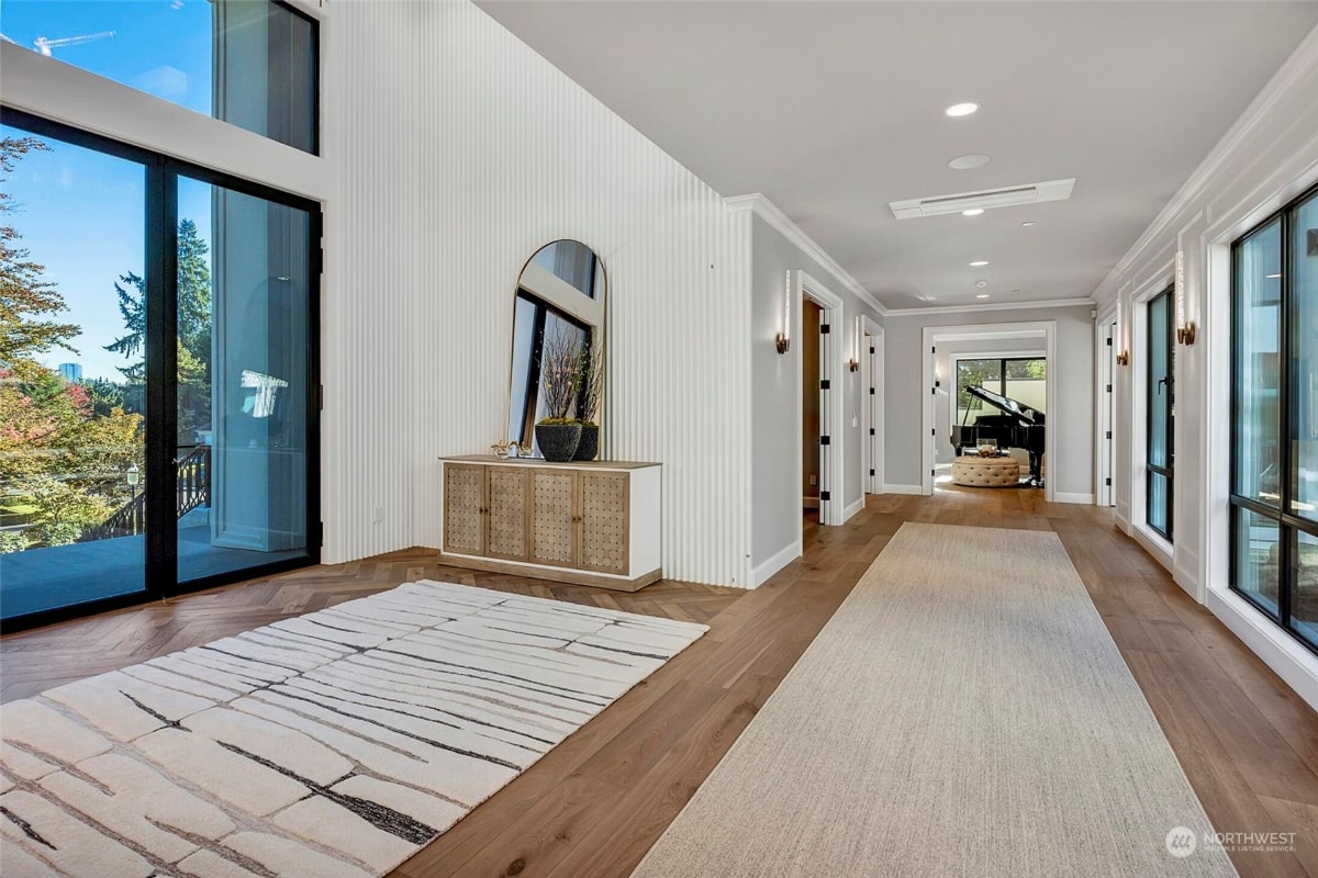 Long hallway with hardwood floors and a large area rug.