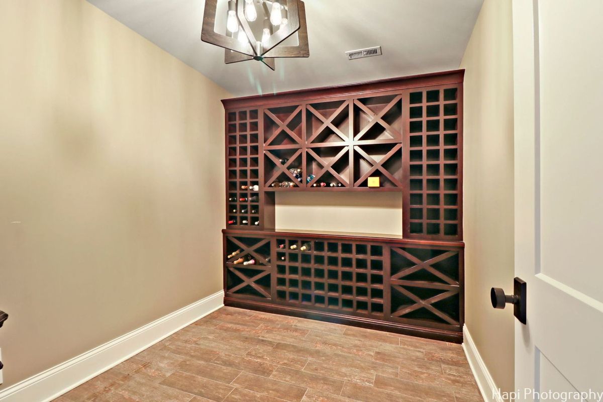 A wine cellar with a large, custom-built wine rack and a chandelier features a sophisticated and elegant design.