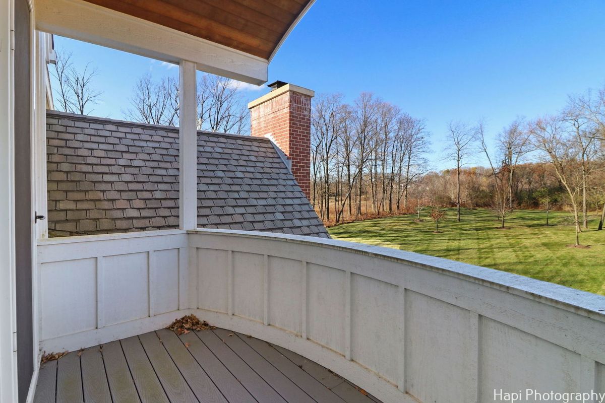 Balcony overlooking a tree-lined landscape offers a peaceful and scenic view.