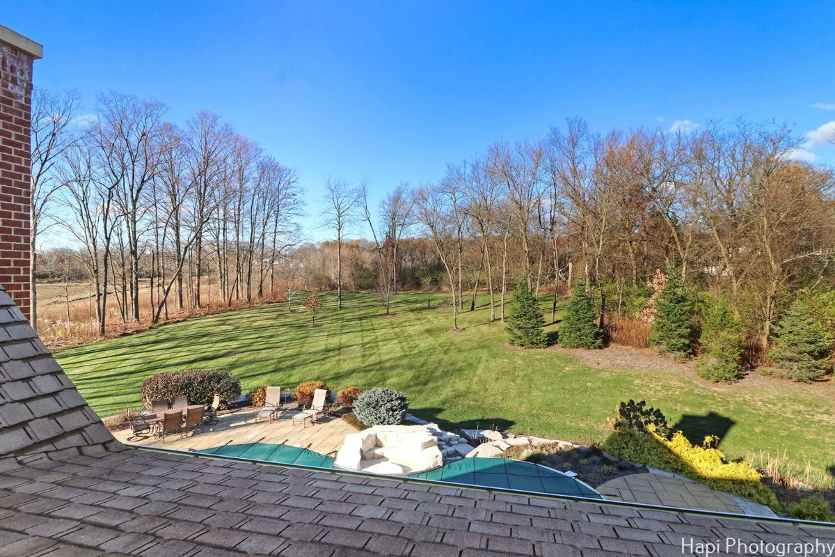 Backyard with a patio, landscaping, and a tree line offers a tranquil and private outdoor space.