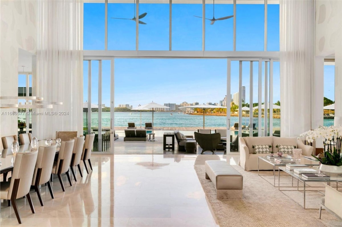 Interior Mansion with floor-to-ceiling sliding glass doors that open onto a patio and waterfront view.