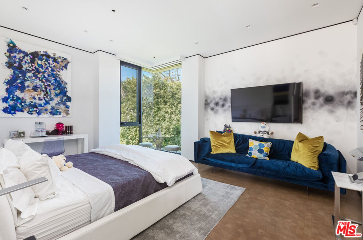 Bedroom features a statement wall and a comfortable seating area.